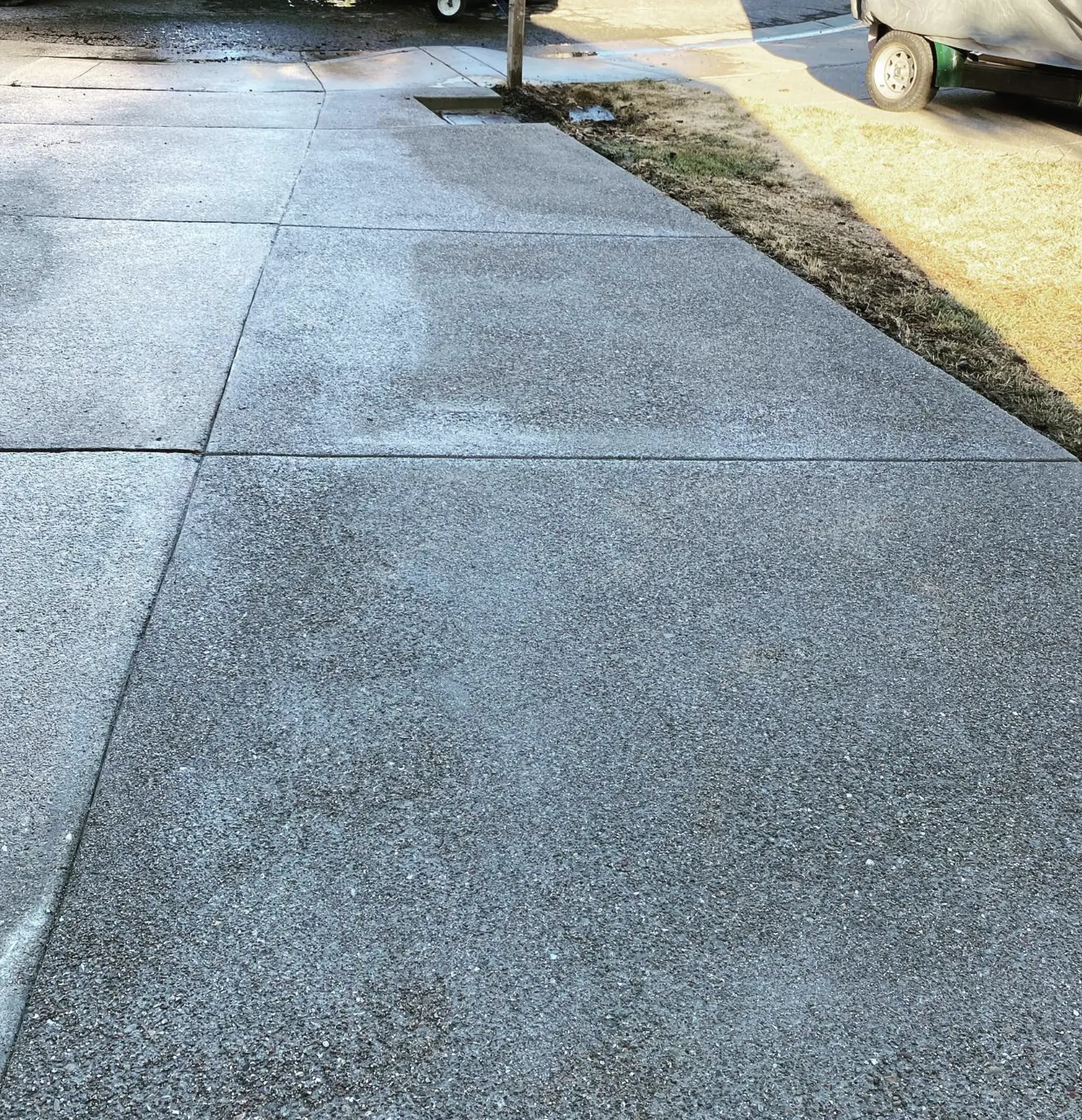 Contractor applying driveway sealer with roller