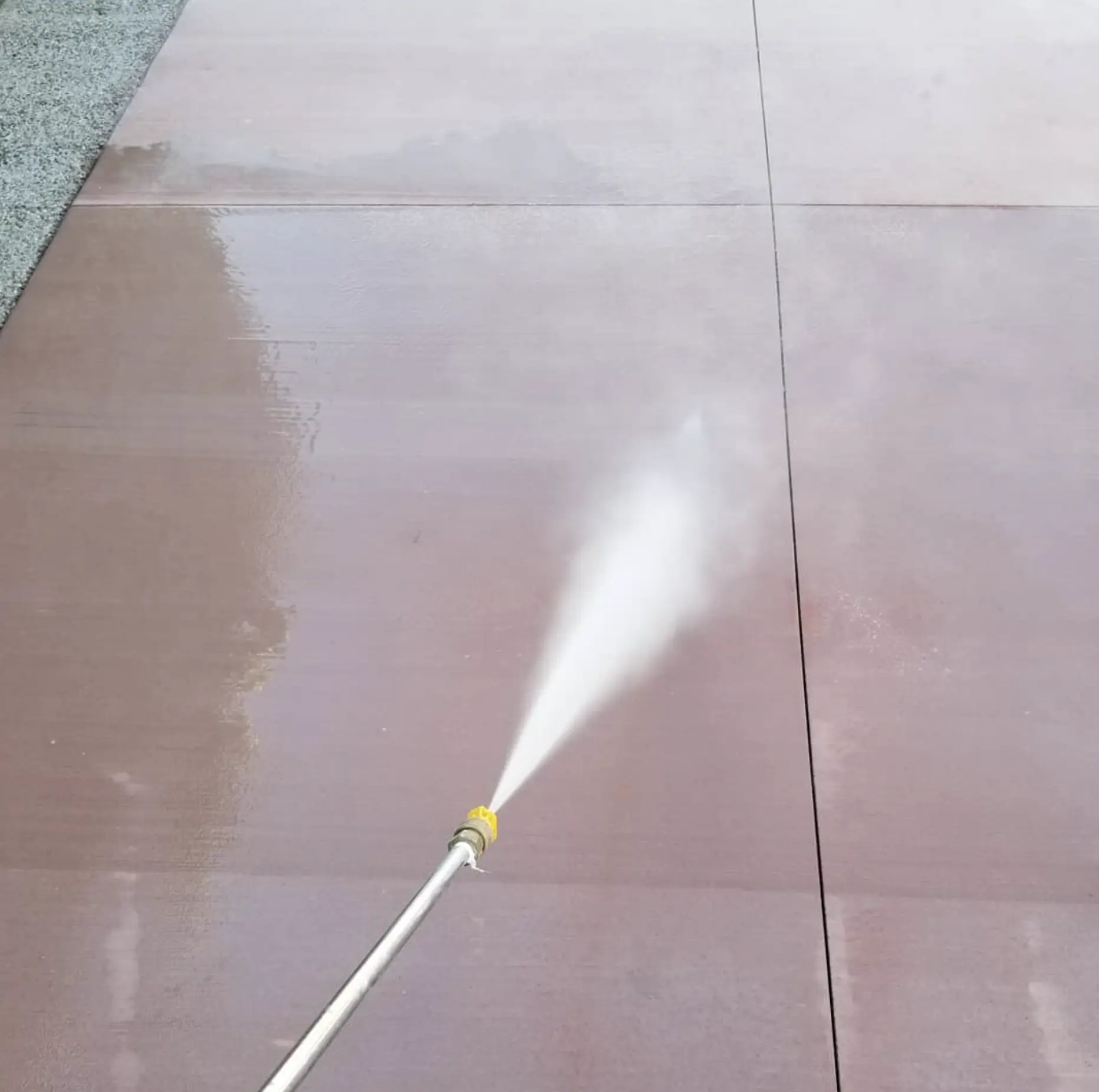 Professional applying acrylic sealer to driveway
