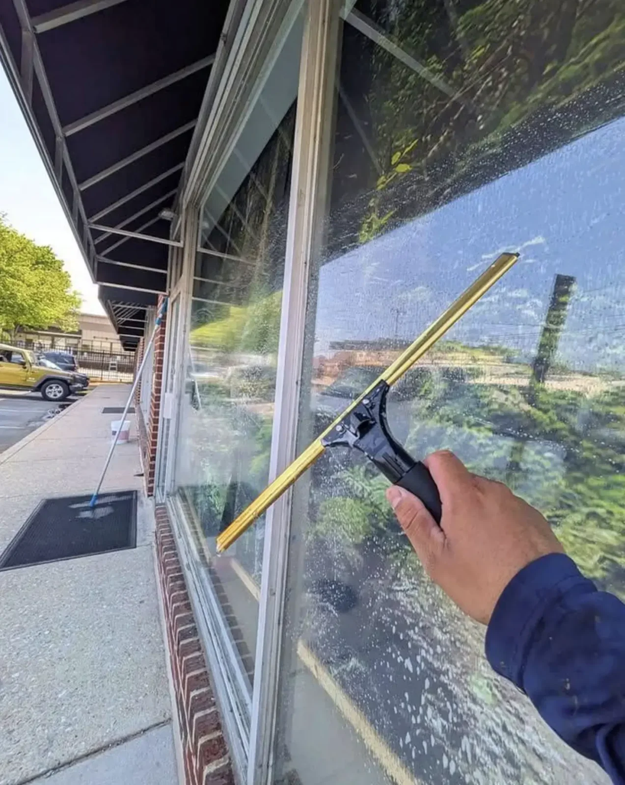 Scrubbing a dirty window with a mop and soapy water