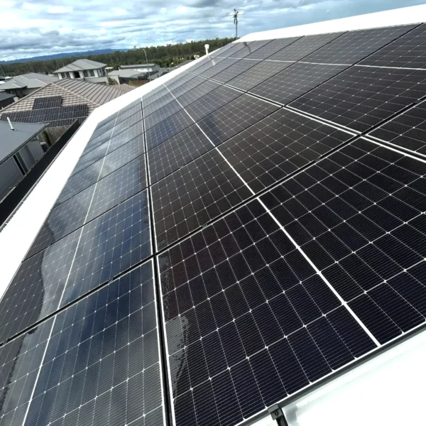 Technician cleaning rooftop solar panels